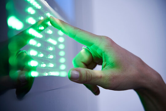 Detail of finger touching green led touchscreen