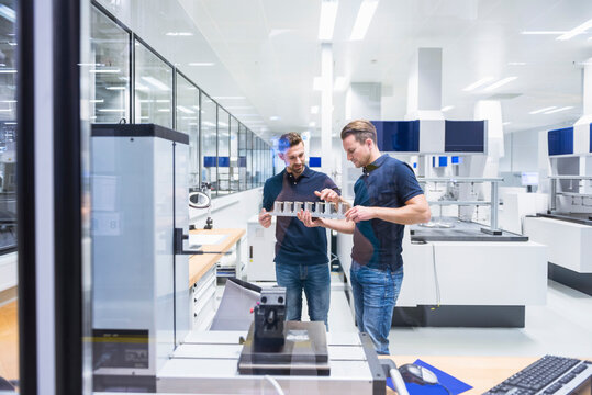 Two men in testing instrument room talking about product