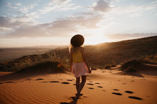 Namibia, Namib desert, Namib-Naukluft National Park, Sossusvlei, woman walking on Elim Dune at sunset