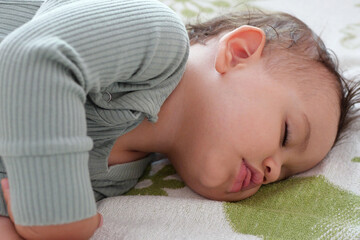 close-up portrait of a beautiful sleeping baby on bed. New family and baby protection from mom concept