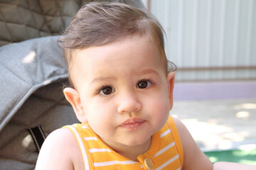 Happy newborn baby makes a funny face. Portrait of a crawling baby in his room close up