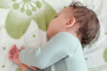 close-up portrait of a beautiful sleeping baby on bed. New family and baby protection from mom concept