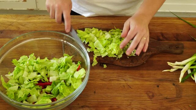 Woman cutting iceberg lettuce for salad
