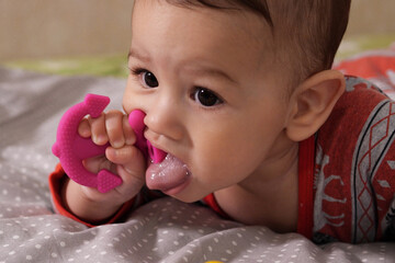 Cute adorable newborn baby playing with colorful rattle toy. baby with teether. six months old lovely baby portrait on white with teether toy