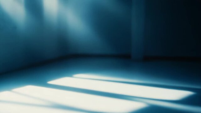 Muted light rays streaming through a rectangular window, creating dramatic shadow patterns and a contemplative atmosphere, focusing on light and dark contrast