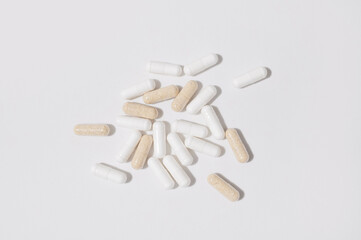 Tablets, capsules, vitamins, and dietary supplements on white background. Minimalistic medical background. Concept of health, pharmaceuticals, disease prevention, and vitamin deficiency. Flat lay 