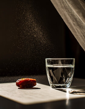 Ramadan maghrib sunbeam with water glass and single date