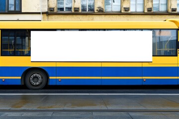 Blank advertising panel on yellow and blue public transport bus against building background in a city during daytime
