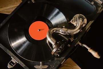 Old gramophone with vinyl record. Portable gramophone, phonograph with vinyl records Vintage gramophone for listening music. Selective focus.
