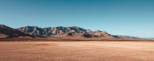 Vast desert plain with distant mountain range under clear blue sky, idea for environmental background, travel concept, minimal nature design, and wide copy space