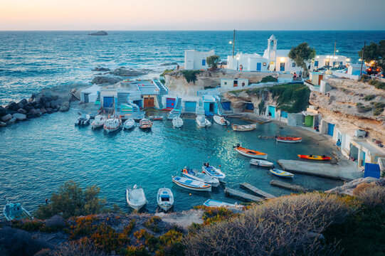 Fishing boats in a picturesque Greek village harbor at dusk, Milos