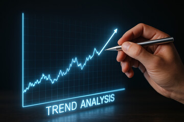 A hand holding a pen pointing at a glowing graph showing trend analysis with steady growth in data.