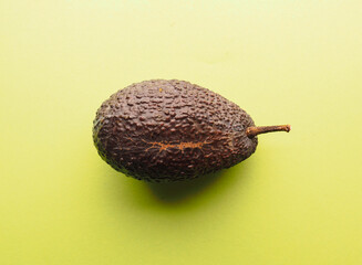 Organic ripe avocado on a green studio background, healthy vegan food concept