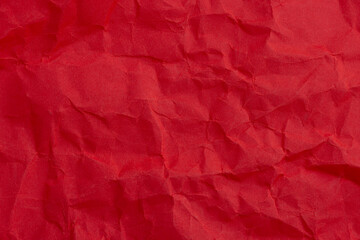 Fototapeta premium Crumpled Red Paper Texture Background,macro close-up patterns,A high-angle, close-up shot of vibrant red crumpled paper texture. The surface features deep creases and irregular folds, 