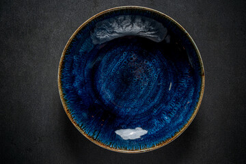 Ceramic plate gleams with rich blue tones and intricate glaze patterns, evoking artistic beauty