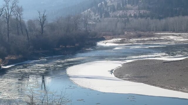 Ice flows down the Bitterroot River in winter during a sunny day in Western Montana near Missoula. 