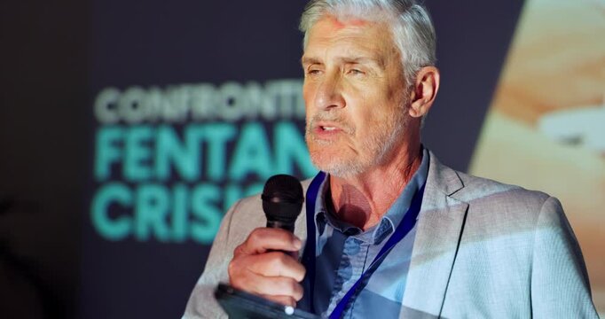 Tablet, stage and man with mic, speaker and serious for fentanyl crisis, healthcare and event. Explaining, presentation and public speaking in seminar, communication and mature person in workshop