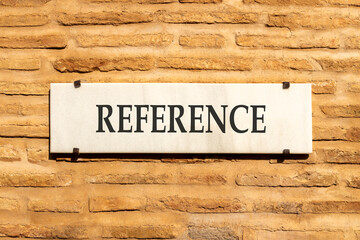 References or reference symbol. Concept word Reference on beautiful white marble sign plate. Beautiful ancient brick wall background. Business references or reference concept. Copy space.