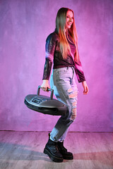 Portrait of dancing young woman with vintage cd recorder