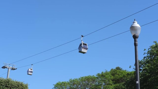 Cable car in Barcelona. Funicular cars pass by the support tower against the clear blue sky on a sunny day. The funicular moves along the cable. A trip by cable car to the observation decks.