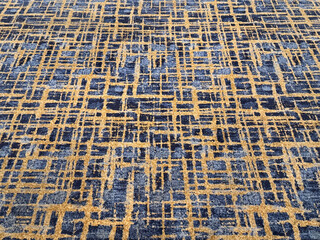 Close up of random linen pattern carpet rug flooring in blue and gold tuft color. Suitable for unique and luxurious grand hotel flooring. Seamless background texture. © TMR Studio