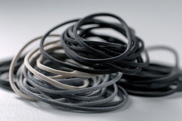 Naklejka premium Close-up of black and gray hair elastics on a neutral background