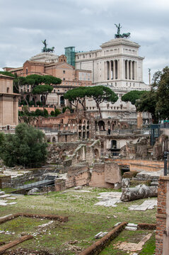 Ancient Roman ruins with the Vittoriano monument in the background. Iconic Rome landmark showing layers of history, architecture and cultural heritage.