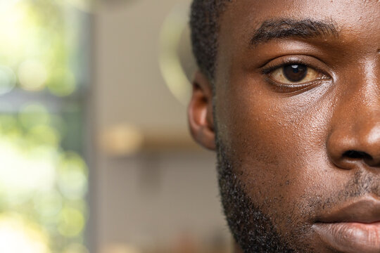 African American adult male showing right half of face at home near window with bokeh mirror