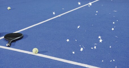 Lying black paddle near court line on blue with two tennis balls and confetti, copy space © vectorfusionart