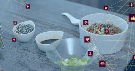 Showing ceramic bowl topped with greens on gray table with spoon sauces glass bowl digital overlay