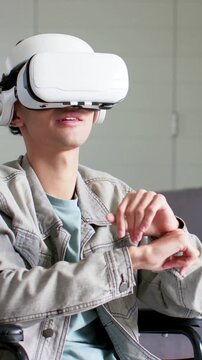 Vertical video: VR on, man at home pinching, tapping, reaching and pointing to use UI, denim jacket
