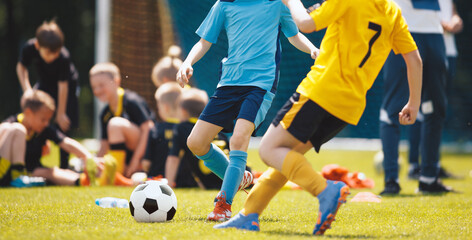 Two soccer players running and kicking a soccer ball. Legs of two young football players on a match. European football youth player legs in action © matimix