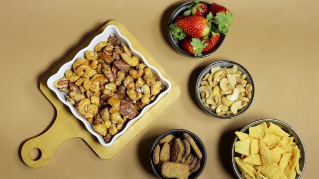 Clapperboard On Film Set Table With nuts, almonds cashews pecans and walnuts coated in smoky spiced caramel and Chips, and Strawberries, biscuit Casual Food Break On Set