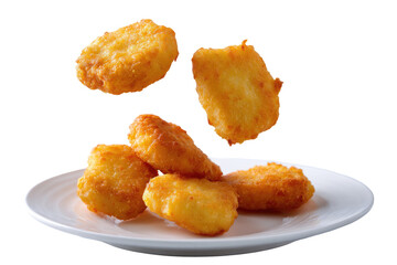 Crispy, golden-brown nuggets, several pieces, appear to be levitating slightly above a white plate