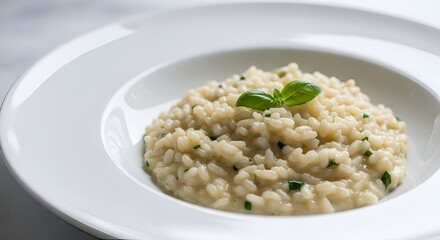Creamy Italian Arborio Risotto Garnished with Fresh Basil, Prepared and Served in a Pristine White Bowl