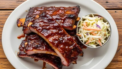 Delicious sticky BBQ pork ribs with sweet and tangy barbecue sauce, served alongside fresh creamy coleslaw on a white plate, perfect for a hearty meal. Summer grilling food.