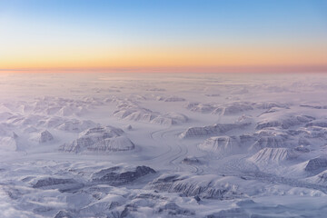 Aerial view of winding glacier through snow covered mountains © Thomas