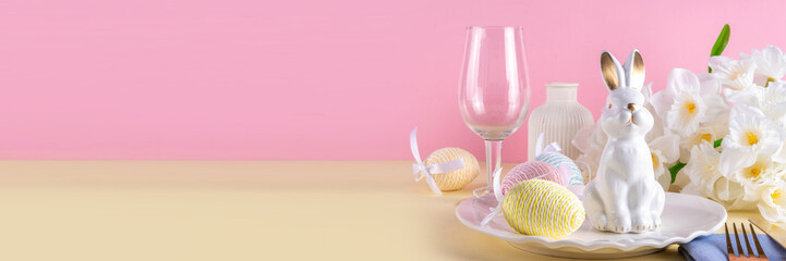 Cute Easter table setting with plate, cutlery set bunny, Easter egg, napkin and spring flowers on...