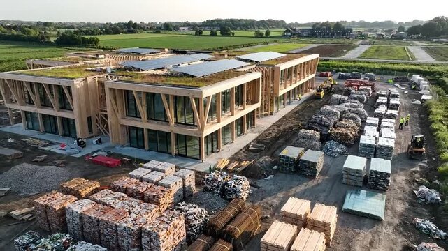 Sustainable building materials stacked outside modern wooden construction site