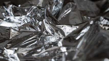 Chaotic dark metallic foil texture with sharp abstract folds