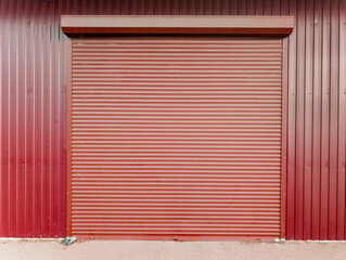 Red metal garage door located in a building in an urban area during daytime