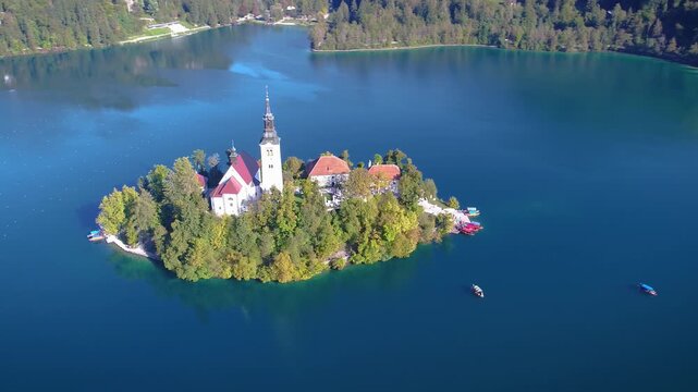 Aerial view of island with church in the middle of alpine lake