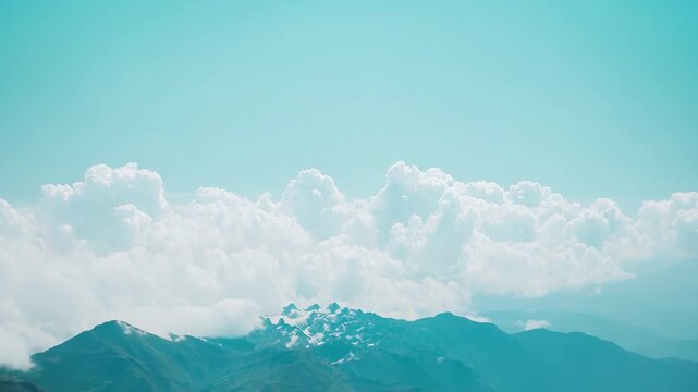 White fluffy clouds forming a vast sea, covering the mountain range with some snow capped peaks emerging under a clear turquoise blue sky, creating a serene and expansive natural landscape