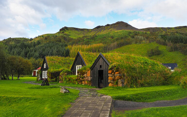 Fototapeta premium Ancient Icelandic village with old wooden stone turf-houses. Skógasafn, beautiful open air complex exploring early Icelandic history and heritage relics. Safnavegur, Skógar, Iceland.