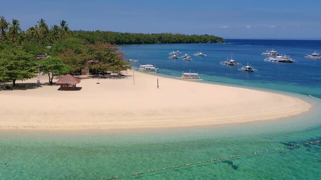 Aerial view of tropical sandy beach with boats in turquoise sea