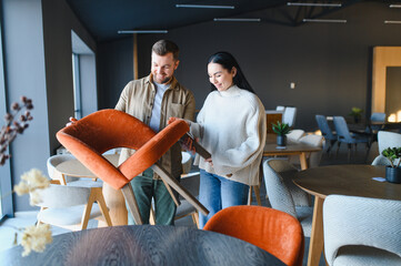 Naklejka premium Couple shopping for new chairs in furniture store