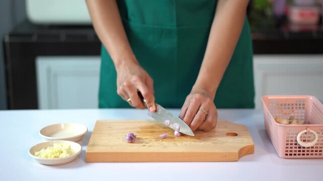 Woman hands slicing small shallots with professional knife