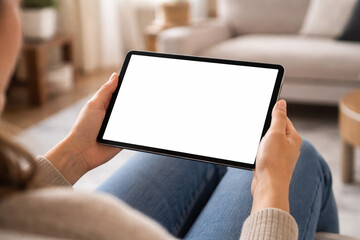 Person Holding Tablet with Blank White Screen on Sofa in Modern Living Room &ndash; UI UX App Mockup 