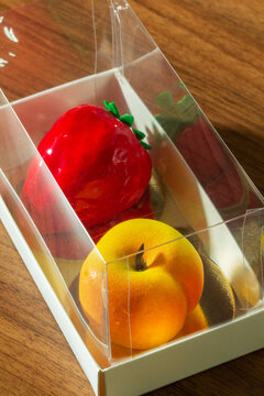 Gift set of mousse cakes in the shape of fruits and berries in a box.