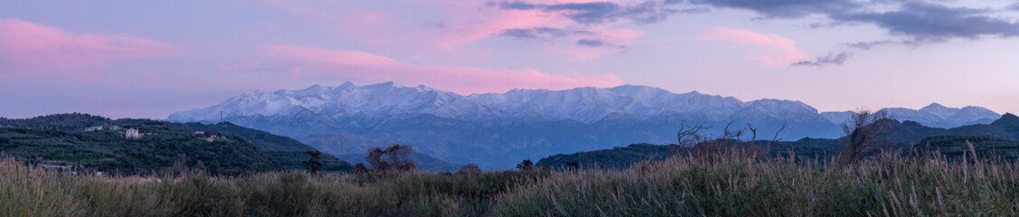 Snowy White Mountains at pink sunset panorama, Crete